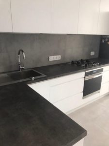 cocina con muebles blancos y mesada gris