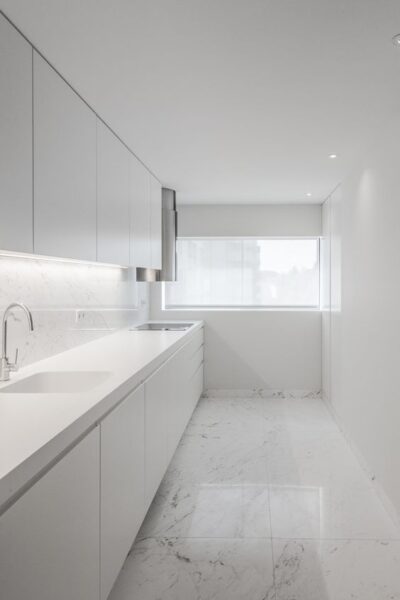 pequeña cocina blanca con piso de marmol