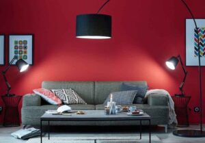 sala de estar con pared roja y sofa gris